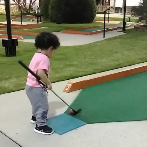 Very Young Child Playing Mini Golf
